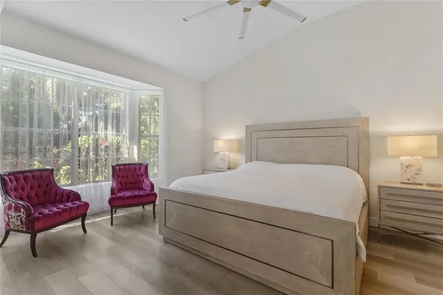 a living room with furniture large windows and wooden floor
