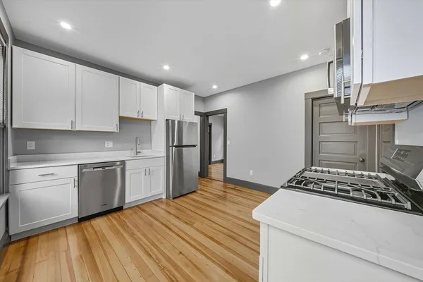 a kitchen with a refrigerator and a stove top oven