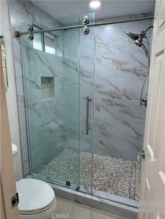 a bathroom with a granite countertop toilet sink and mirror