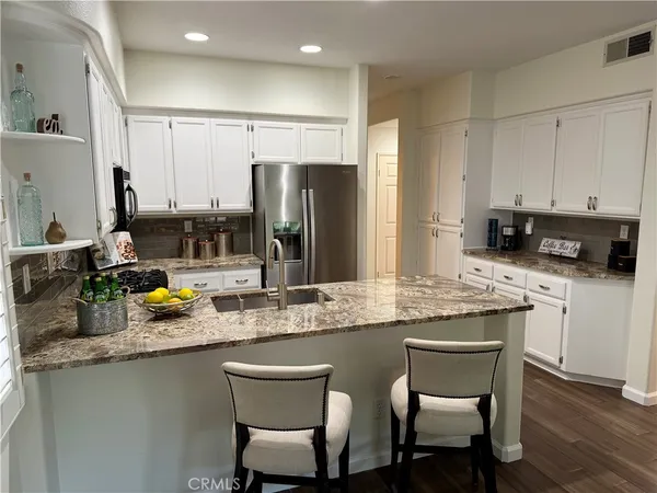a kitchen with stainless steel appliances granite countertop a sink refrigerator and microwave
