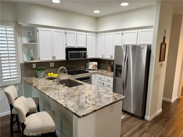 a kitchen with stainless steel appliances granite countertop a stove a microwave a sink and cabinets