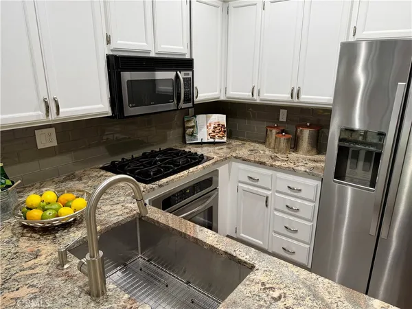 a kitchen with white cabinets and white appliances