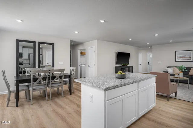 a kitchen with stainless steel appliances granite countertop a stove a table and chairs