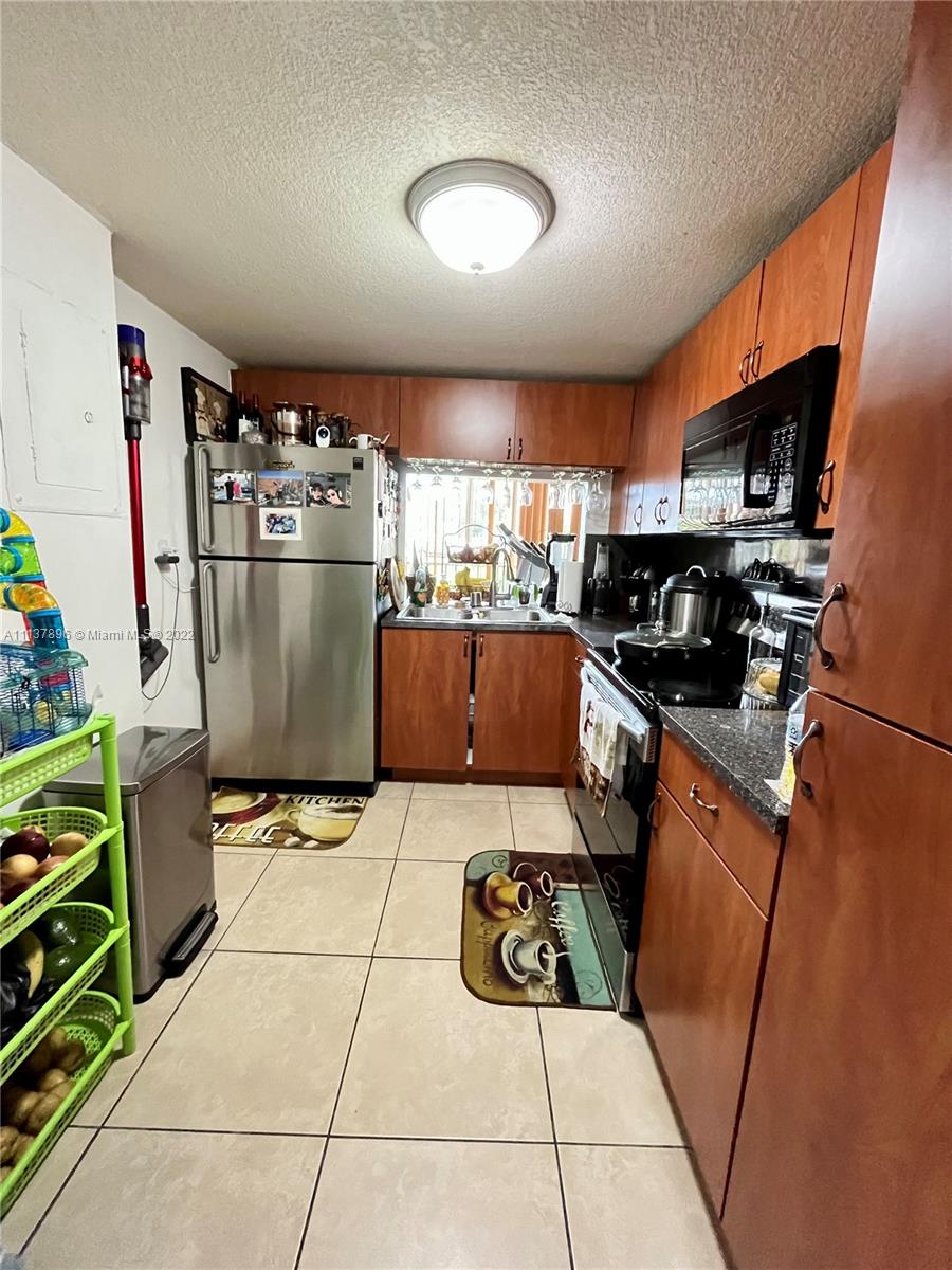 a kitchen with stainless steel appliances granite countertop a refrigerator a stove a sink dishwasher and a refrigerator