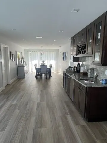 a dining hall with stainless steel appliances granite countertop a kitchen island a stove a table and chairs in it