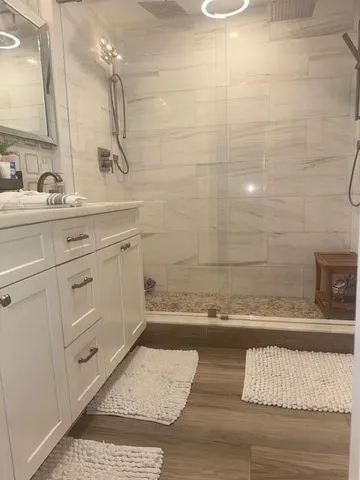 a large bedroom with a bed and glass walk in closet