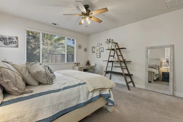 a bed sitting in a spacious bedroom next to a window