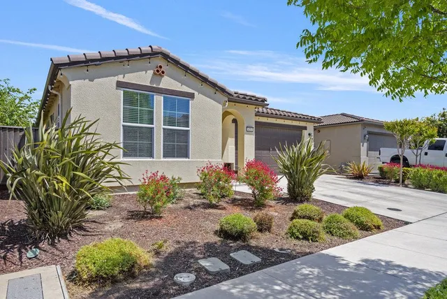 a front view of a house with a garden