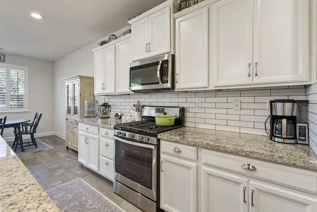 a large kitchen with a center island and stainless steel appliances