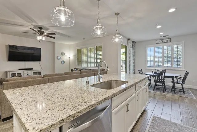 a large white kitchen with a large island oven a stove a sink and a refrigerator