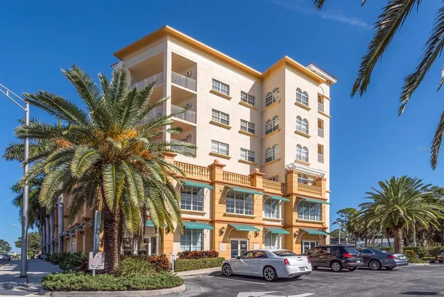 a front view of a building with palm trees