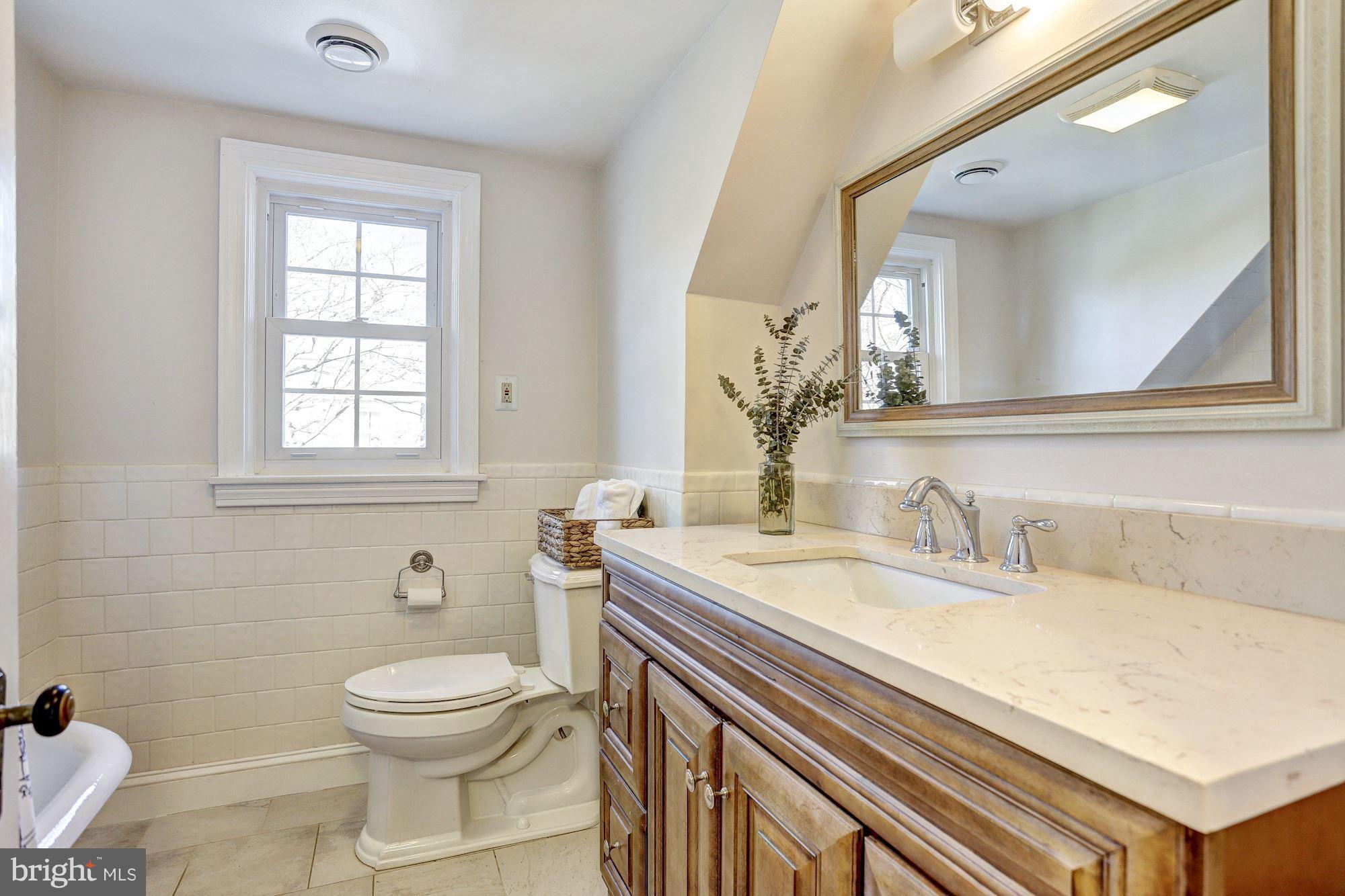 408 Dunkirk Road Baltimore, MD 21212 - Photo 17 of 22 a bathroom with a granite countertop toilet sink and mirror