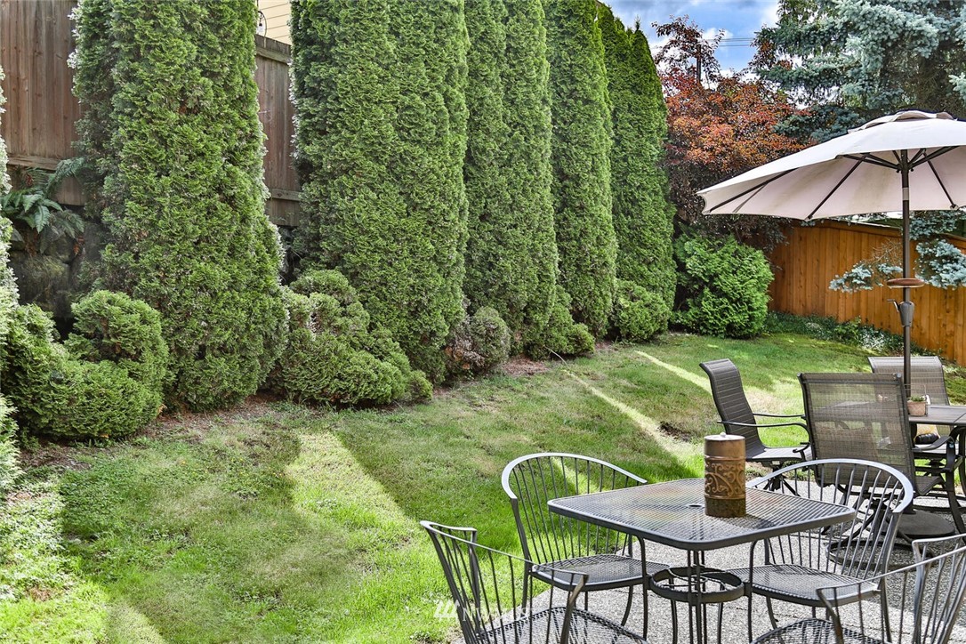 2432 195th Place Southeast, Unit B Bothell, WA 98012 - Photo 31 of 34 a patio with a table and chairs under an umbrella