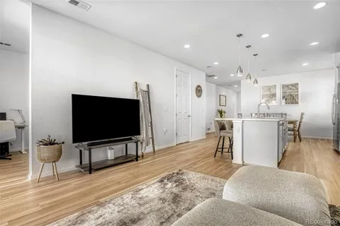 a living room with a flat screen tv a dining table and a flat screen tv
