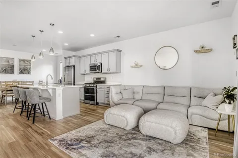 a living room with furniture kitchen view and a dining table