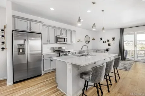 a kitchen with kitchen island a refrigerator stove microwave and cabinets