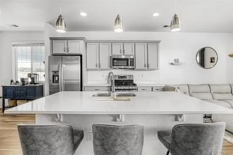 a kitchen with stainless steel appliances granite countertop a sink a stove and a refrigerator