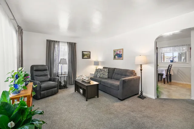 a living room with furniture and a potted plant
