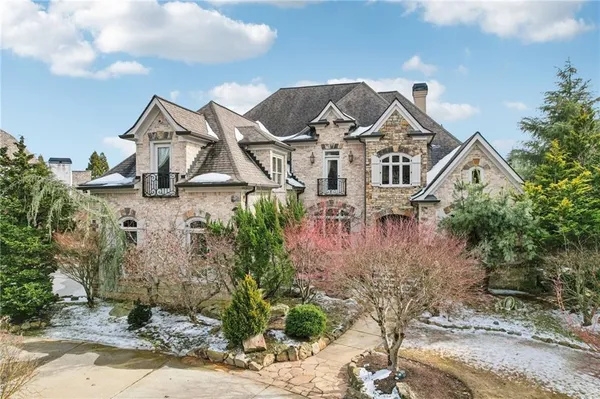 a front view of a house with a yard and trees