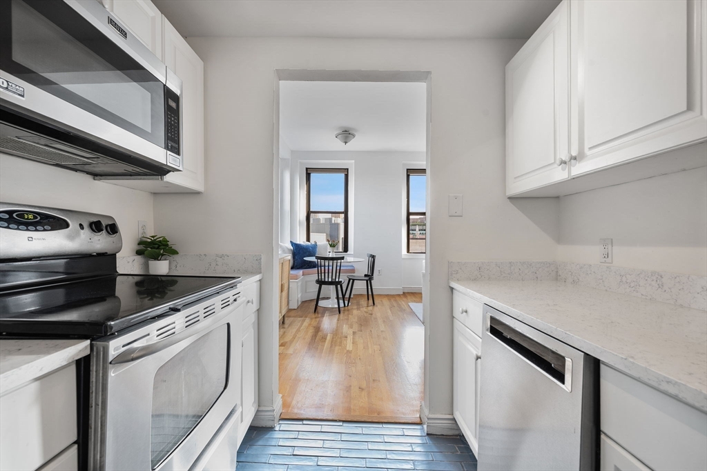 4 Charlesgate East, Unit 601 Boston, MA 02215 - Photo 14 of 33 a kitchen with stainless steel appliances granite countertop a stove a sink and a microwave