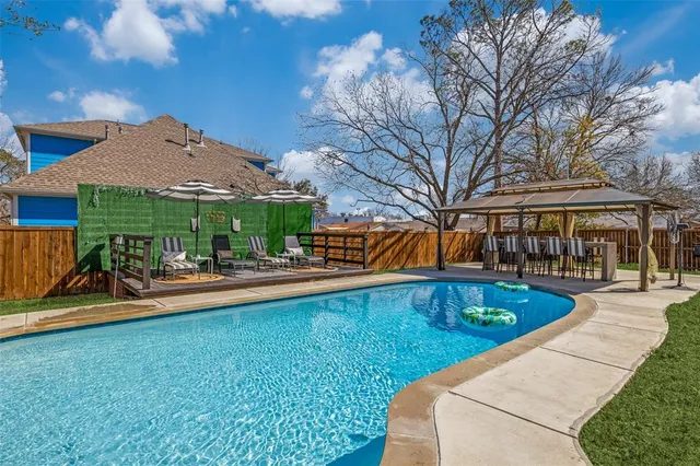 a view of a house with swimming pool and sitting area