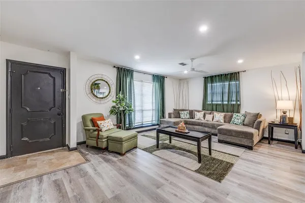 a living room with furniture and wooden floor