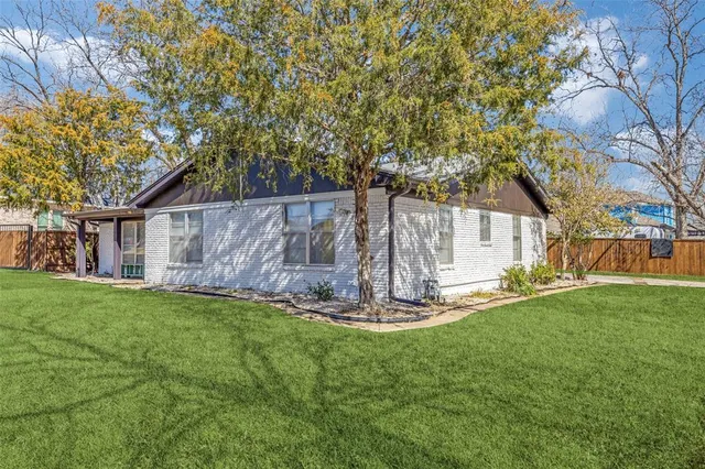 a view of a backyard with table and chairs and wooden fence