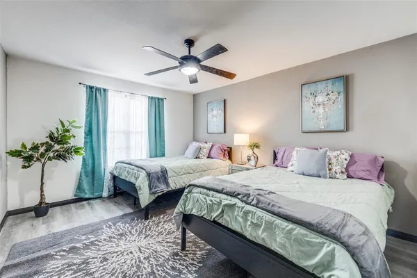 a bedroom with a large bed and a potted plant