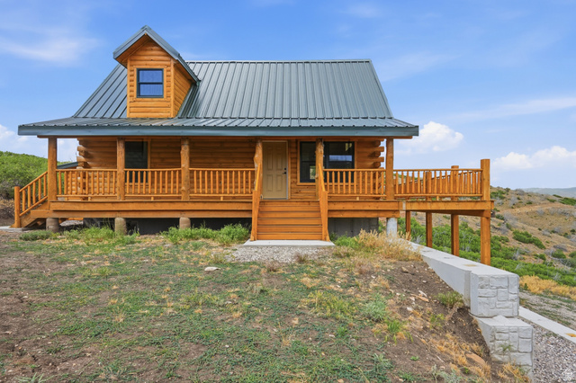 20 Q Puma Road Fairview, UT 84629 - Photo 26 of 27 Log home featuring a covered front porch with wood railings and steps, a dormer window, and a metal roof
