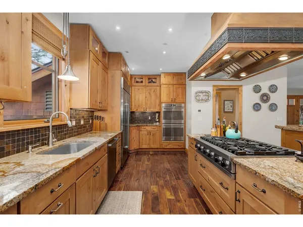 a kitchen with stainless steel appliances granite countertop a stove a sink and a refrigerator