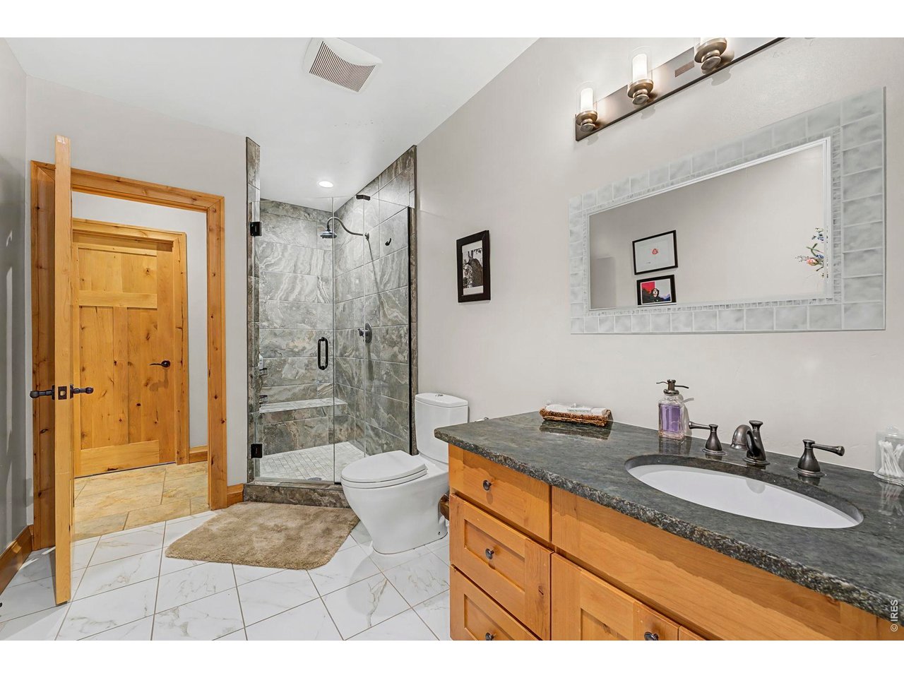 3135 11th Street Boulder, CO 80304 - Photo 42 of 50 a bathroom with a granite countertop sink a mirror a bathtub and shower