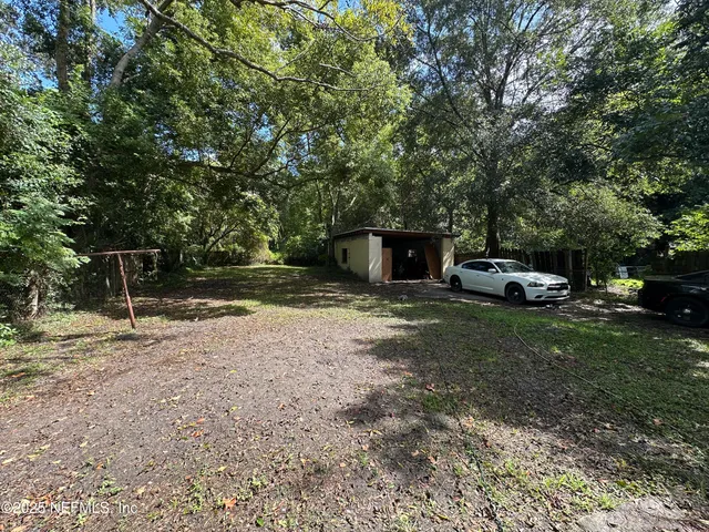 a big yard with table and trees