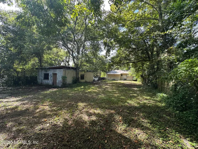 a backyard of a house with table and chairs