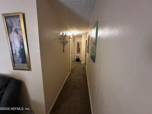 a view of a hallway with paintings on the wall