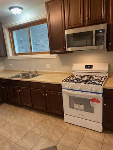 a kitchen with granite countertop stainless steel appliances a stove microwave and sink
