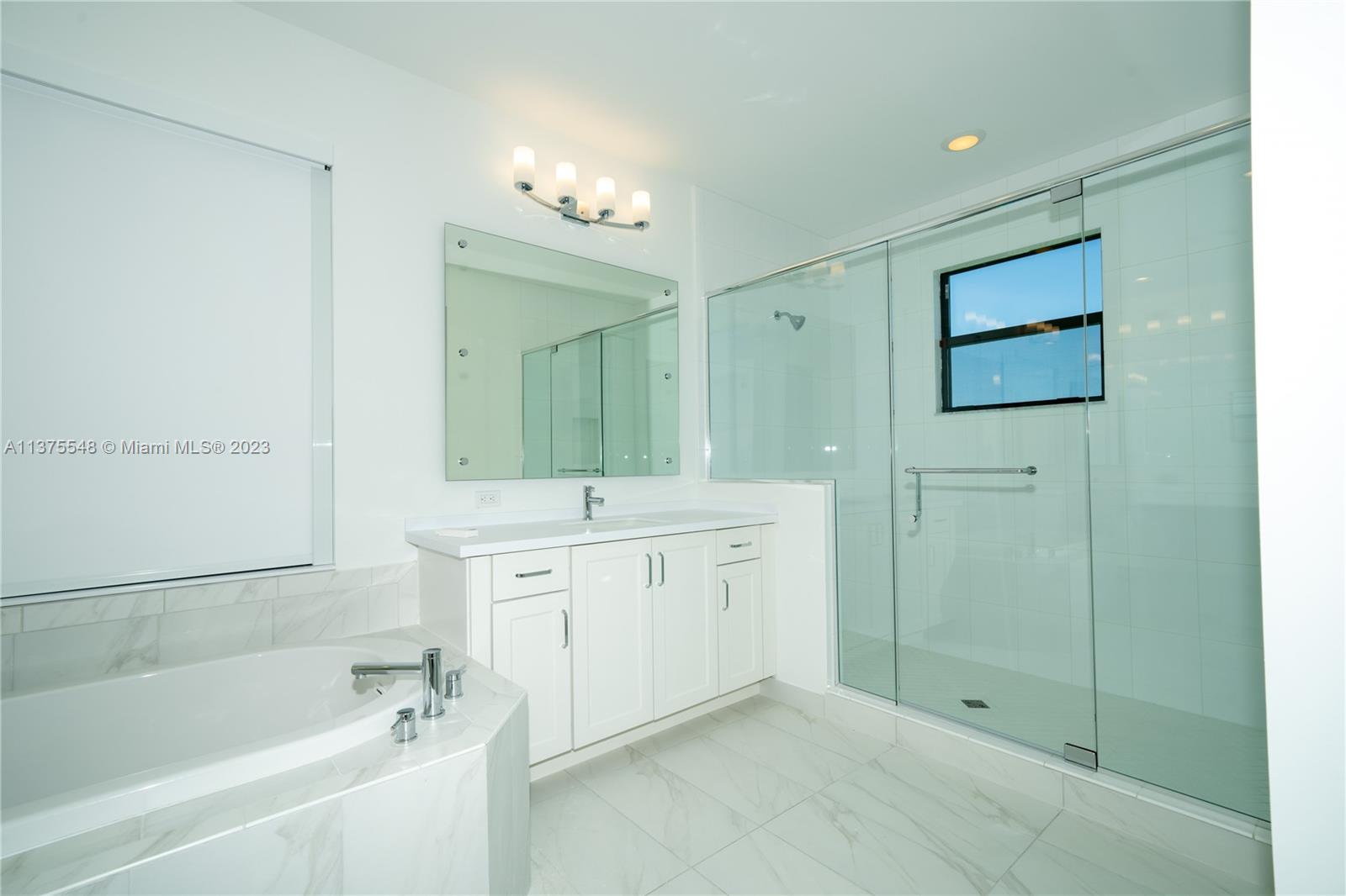 17232 Teton River Road Boca Raton, FL 33496 - Photo 15 of 28 a spacious bathroom with a mirror a shower and a sink