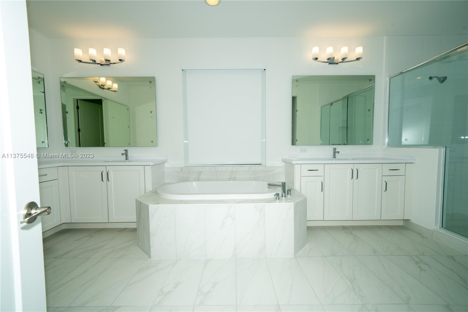 17232 Teton River Road Boca Raton, FL 33496 - Photo 16 of 28 a spacious bathroom with a bathtub sink and mirror