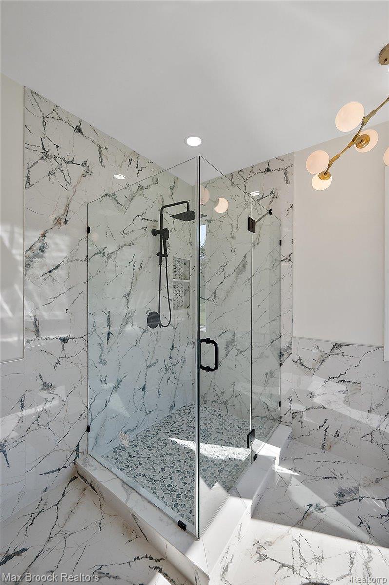 4597 Clarkston Road Clarkston, MI 48348 - Photo 33 of 74 Glass-enclosed shower with a rainfall showerhead, handheld sprayer, and built-in shelving