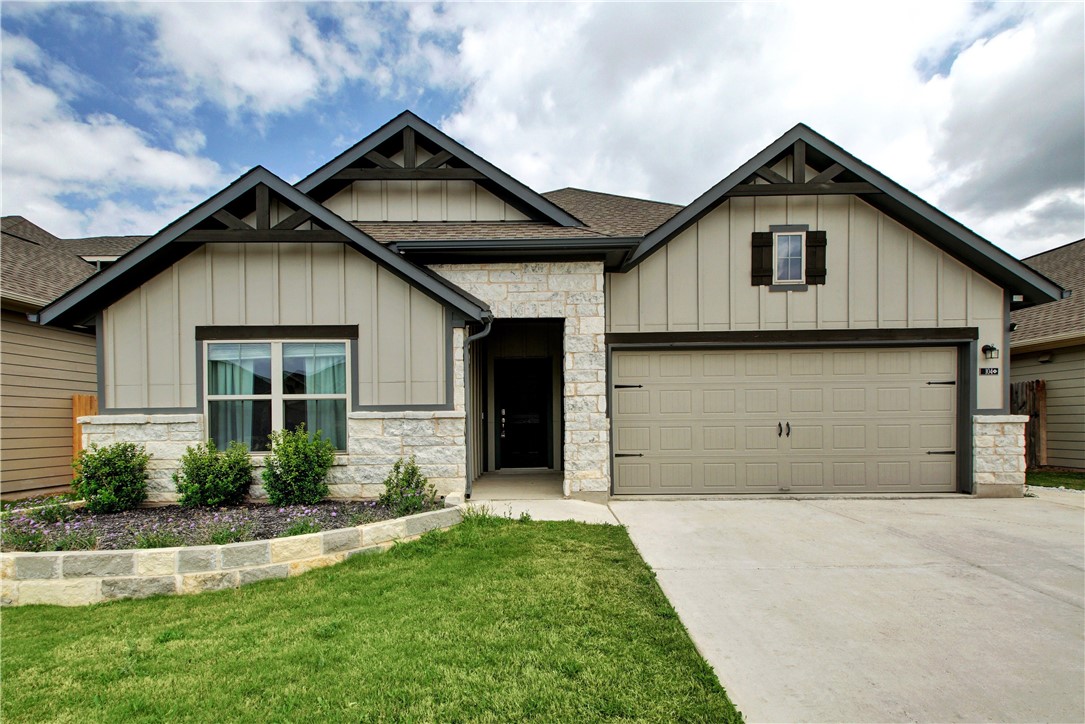 a front view of a house with a garden and plants