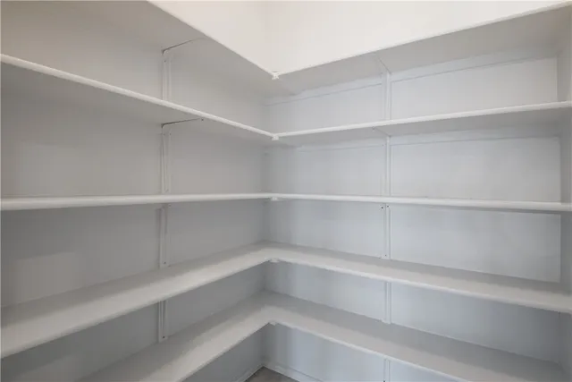 a view of walk in closet with empty racks