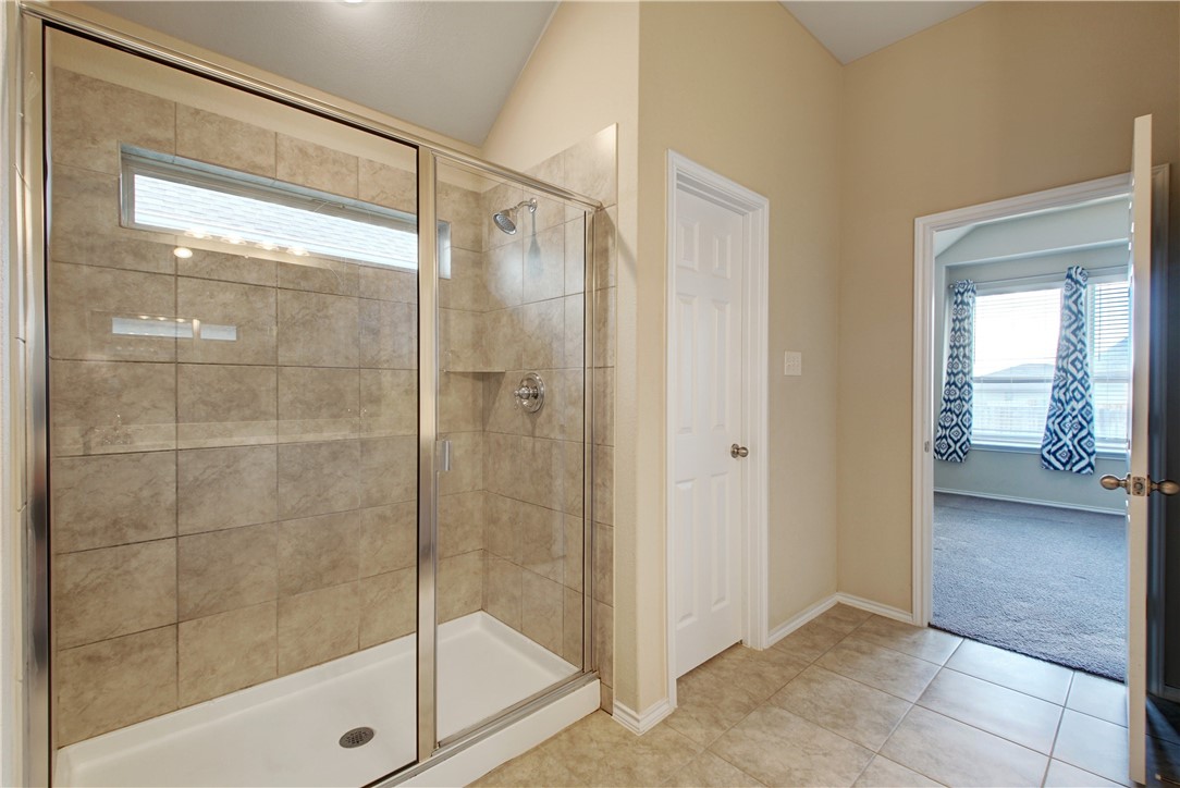 104 Finley Street Hutto, TX 78634 - Photo 15 of 37 a bathroom with a glass shower door