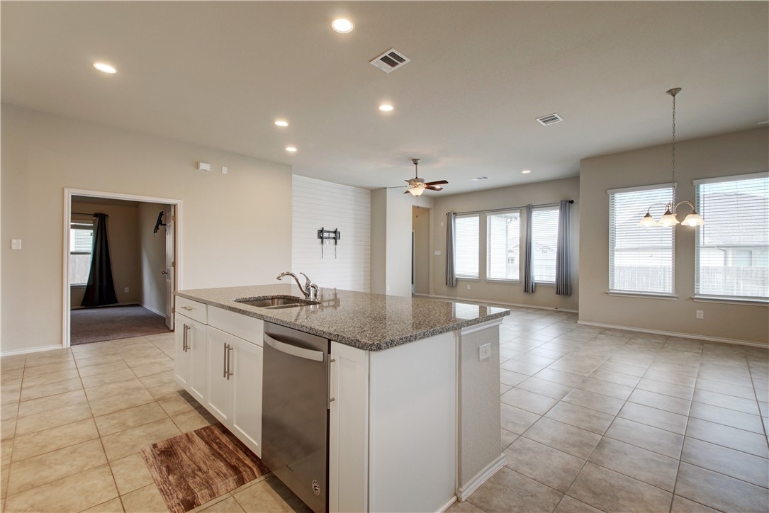 104 Finley Street Hutto, TX 78634 - Photo 18 of 37 a kitchen with stainless steel appliances granite countertop a sink and a stove