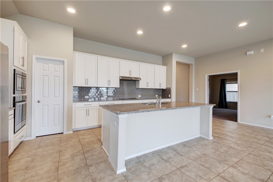 104 Finley Street Hutto, TX 78634 - Photo 9 of 37 a large white kitchen with cabinets