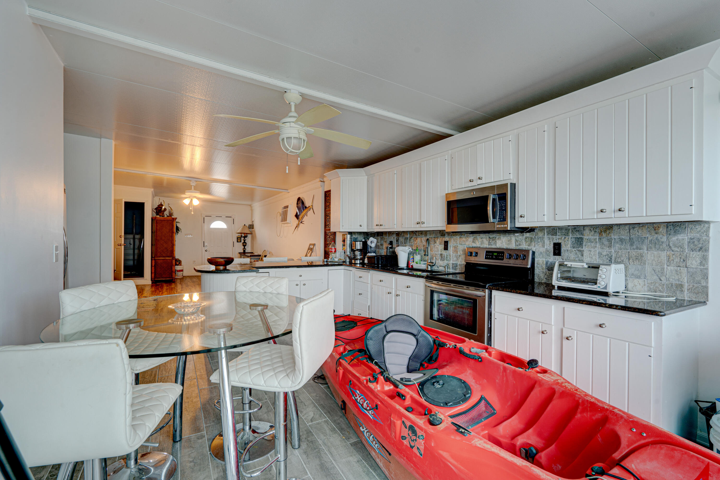 1361 Overseas Highway, Unit E11 Marathon, FL 33050 - Photo 29 of 46 a kitchen with stainless steel appliances granite countertop a stove a sink dishwasher a microwave oven with a dining table and chairs