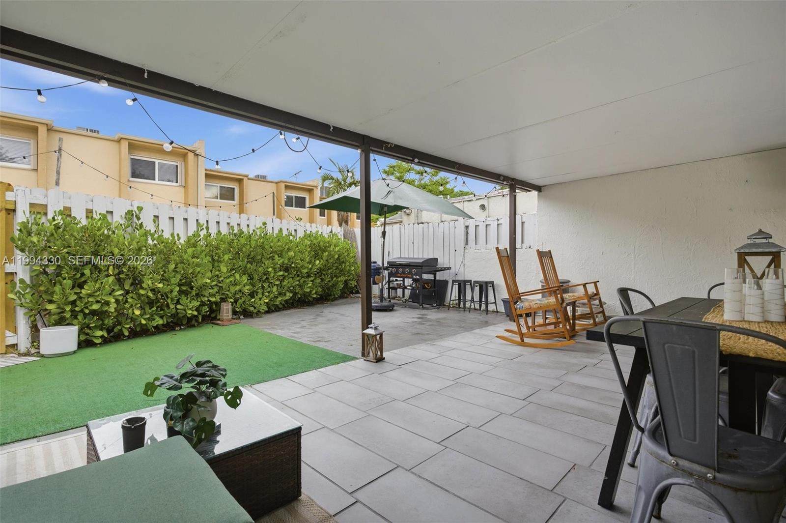 14019 Southwest 67th Terrace Miami, FL 33183 - Photo 35 of 36 a view of a patio with table and chairs potted plants with wooden floor