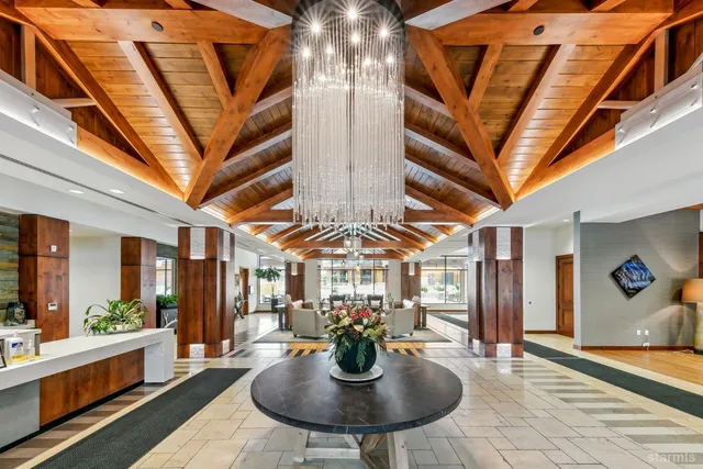 a view of a dining room with furniture a chandelier and wooden floor