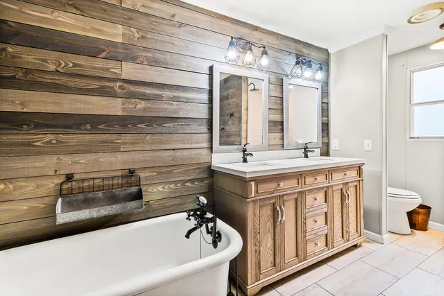a bathroom with a double vanity sink a mirror and a bathtub