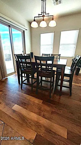 a kitchen with stainless steel appliances granite countertop a table chairs and a refrigerator