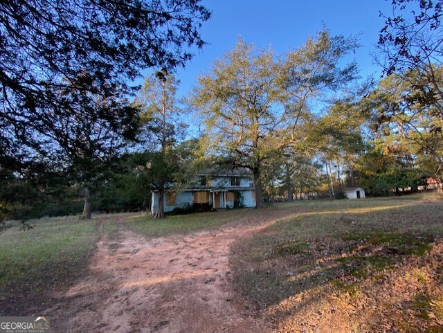 a view of a field with trees in the background