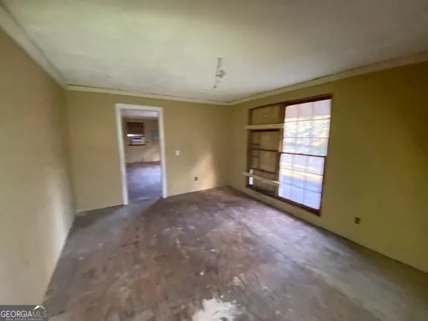 a view of empty room with window and wooden floor